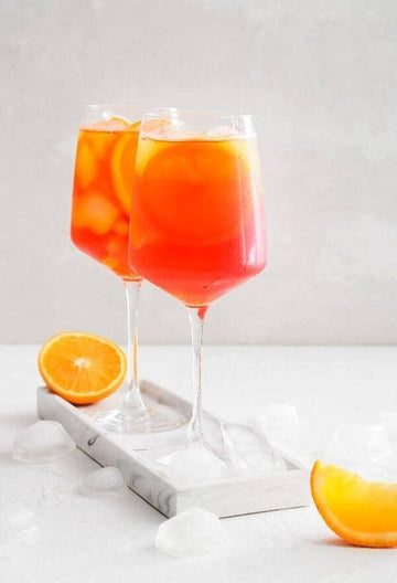 Two glasses of Classic Spritz Mocktail on a kitchen bench made using lyres italian spritz