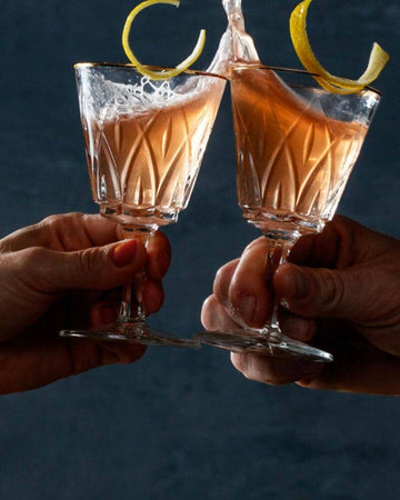 Two glasses of Cosmopolitan mocktail garnished with lemon peel