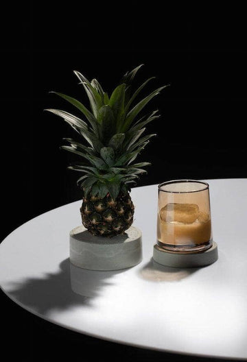 Rum Mocktail in a glass with a clear ice block next to a pineapple