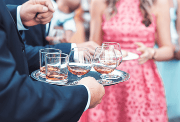 A man holding a tray with non-alcoholic drinks Sans Drinks