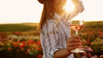 Woman holding a glass of non-alcoholic wine at a vineyard 