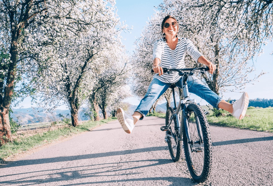 A happy woman rinding a bike