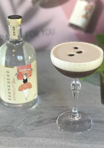 Espresso Martini Mocktail garnished with coffee beans next to a bottle of clovendoe SPROUT