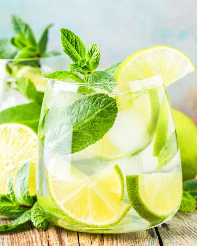 Gin mojito mocktail garnished with lime slices and mint leaves