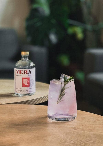 Pink Gin mocktail garnished with a rosemary sprig
