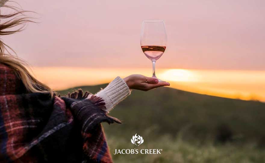 A woman holding a glass of Jacob's Creek non-alcoholic wine