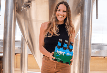 Jaz Wearin, co-founder of NORT holding a 6 pack of Nort non-alcoholic beer