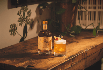 A bottle of Lyre's Amaretti next to Amaretti Sour Sans Drinks