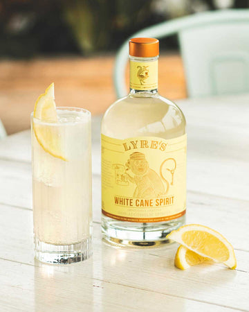 Collins gin mocktail next to a bottle of Lyre's white cane spirit