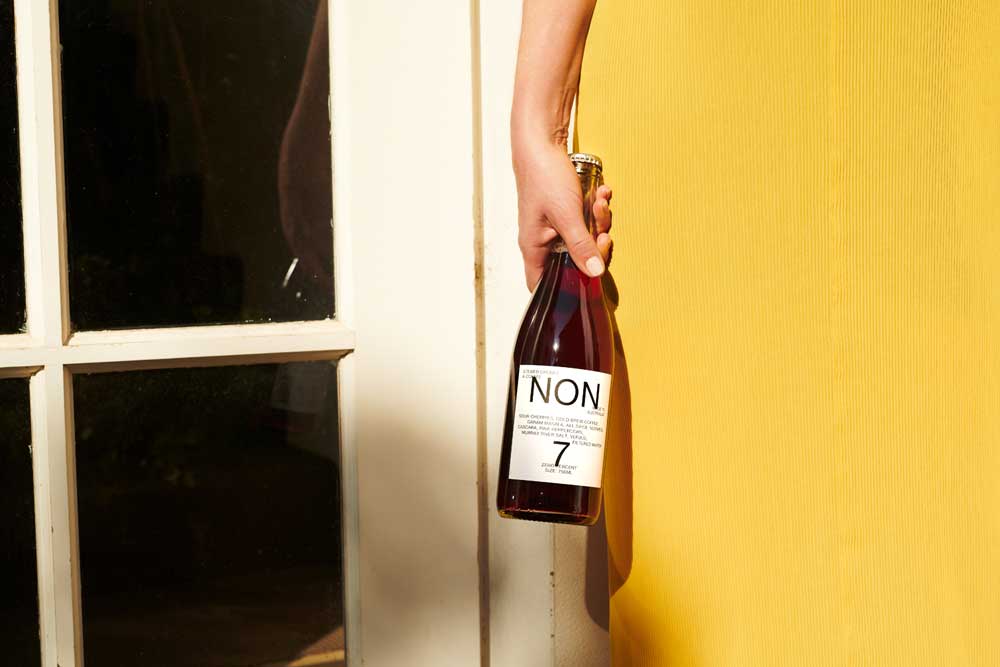 NON 7 bottle in Female hand Sans Drinks