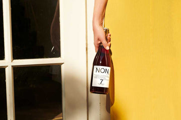 NON 7 bottle in Female hand Sans Drinks