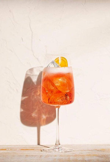 Non-alcoholic spritz in a glass filled with ice and garnished with a slice of orange