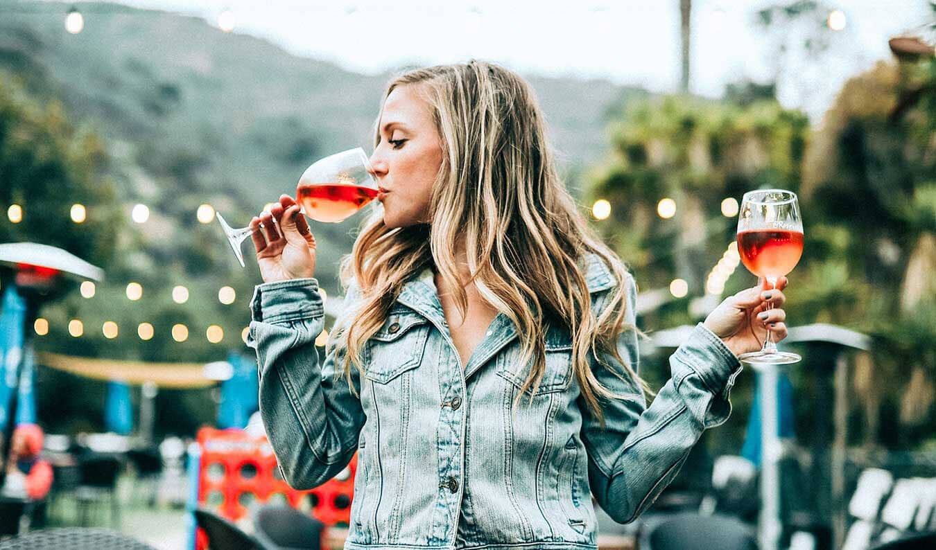 Lady tasting 2 glasses of non-alcoholic wine Sans Drinks