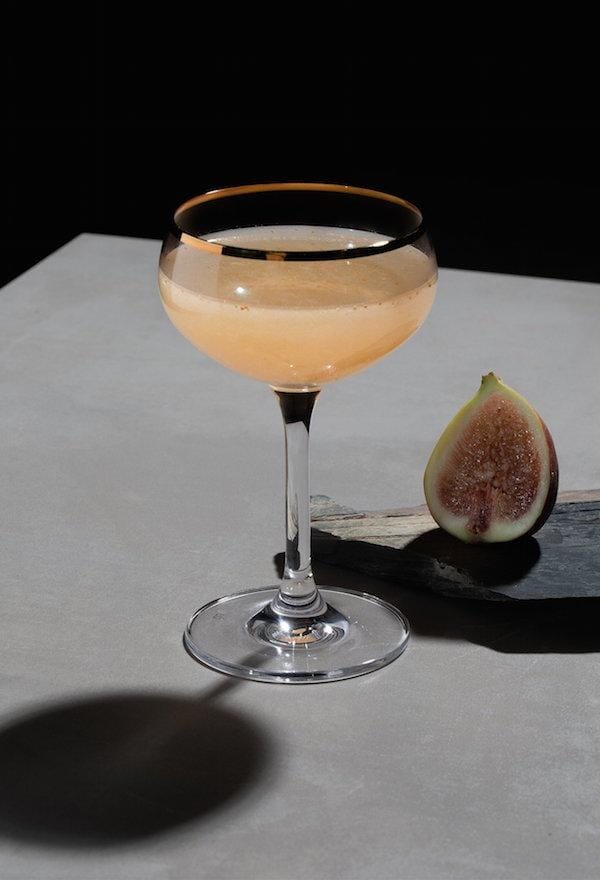 Gin mocktail make with Ovant Grace next to a fig fruit