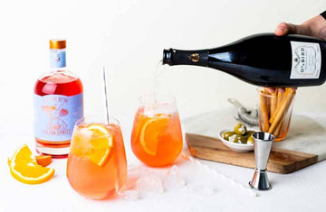 A bottle of Odd Bird non-alcoholic prosecco being poured into a glass filled with Lyre's italian spritz