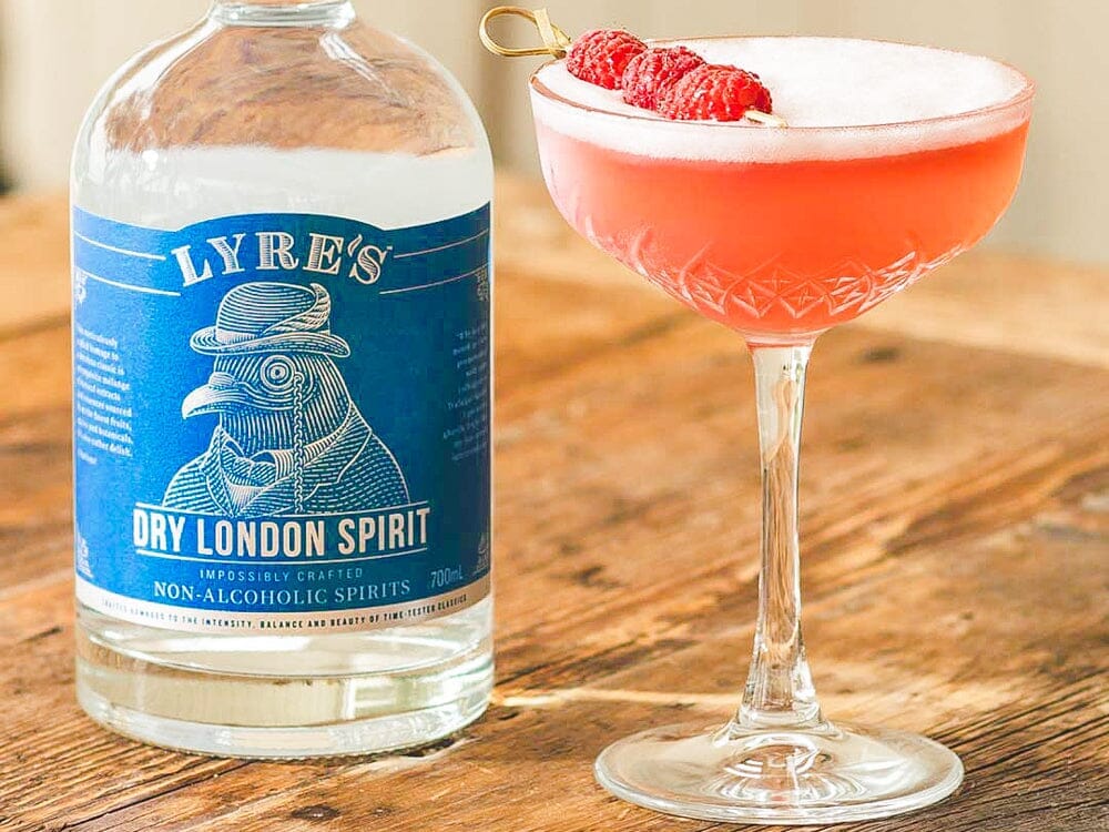Bottle of Lyre's Dry London Spirit next to a glass of clover club gin mocktail