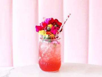 Cosmopolitan Spritz garnished with edible flowers and made with Ms Sans Cosmopolitan