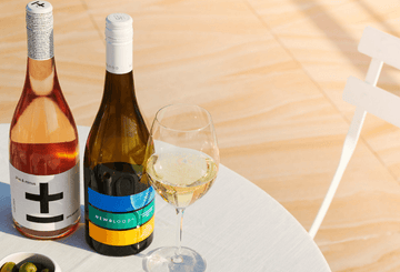 Two bottles of Low sugar non-alcoholic wines and a glass of non-alcoholic wine