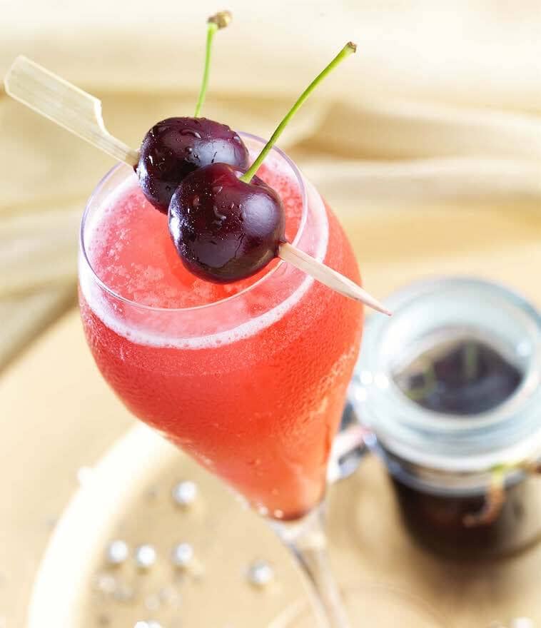 Sparkling Rosé Mocktail made with Esiberg Alcohol-Free Sparkling Rose wine garnished with two fresh cherries Sans Drinks