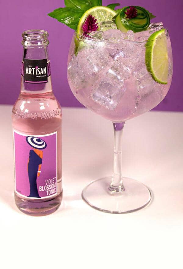 Artisan Drinks Violet Blossom Tonic and a glass of blossom gin mocktail garnished with lime wheels