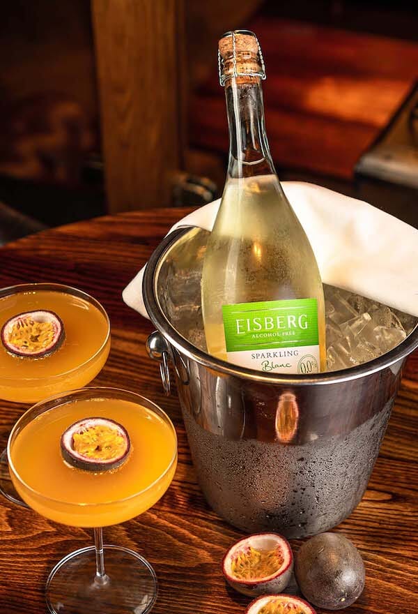 Two glasses of Eisberg's Virgin Martini and a bottle of Eisberg Sparkling White on a drink ice bucket filled with ice