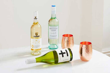Group 3 of White non-alcoholic wine bottles and two copper mugs