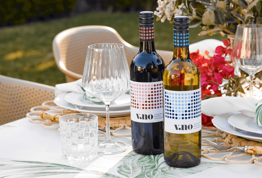 Two bottles of V.NO non-alcoholic wine on a dinner table