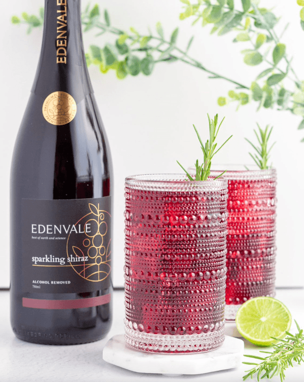 Two glasses of non-alcoholic Red Wine Ginger Spritzer next to a bottle of Edenvale Premium Reserve Sparkling Shiraz