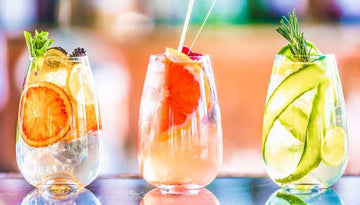 Three cups of mocktails garnished with fruits Sans Drinks