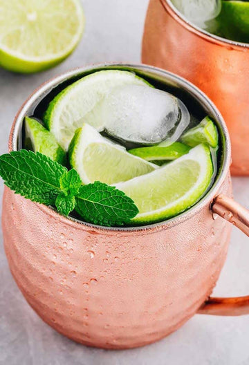 Mexican Mule Mocktail on a copper mug garnished with lime slices and mint leaves