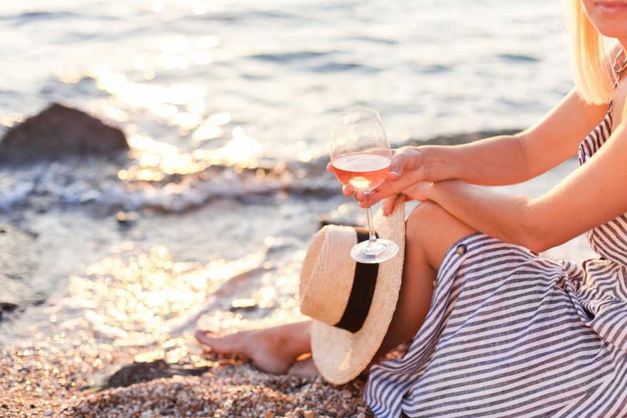 Women enjoying a glass of non-acloholic wine at the beach Sans Drinks