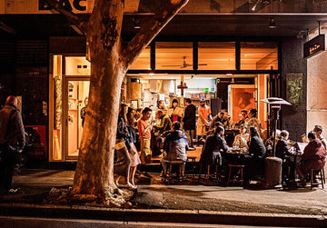 People dining in a crowded restaurant Sans Drinks