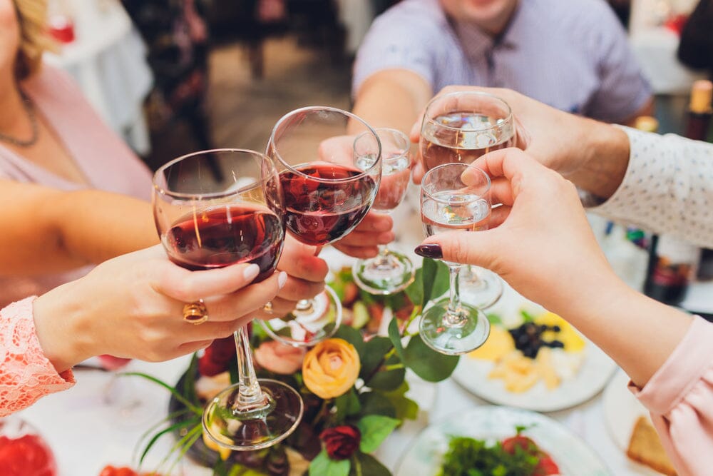 Group of people clinking non-alcoholic red wine glasses