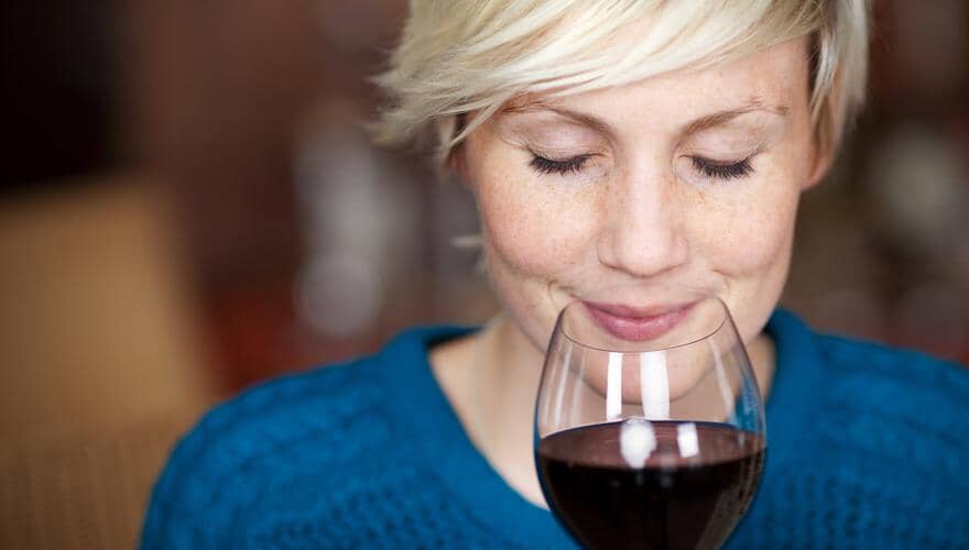 Woman enjoying a glass of non-alcoholic red wine Sans Drinks