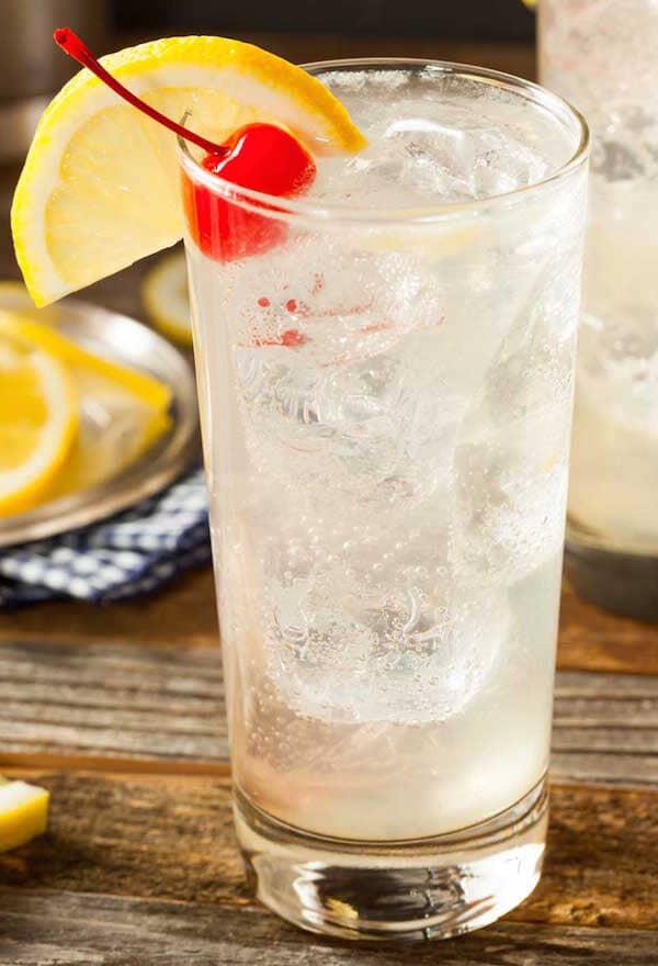 Virgin Tom Collins made with Sans Bar Notting Hill Stroll and garnished with a lemon slice and fresh cherry Sans Drinks