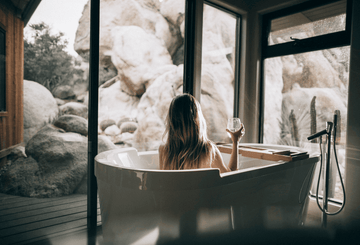 A woman enjoying a glass of non-alcoholic wine on a bath tub Sans Drinks
